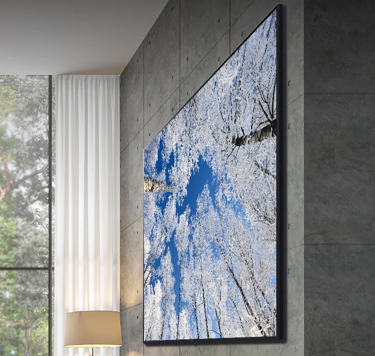 Camera di chuyển từ cận cảnh đỉnh TV xuống cận cảnh mặt trước của TV. Màn hình TV hiển thị cực quang màu xanh lá cây. Camera phóng to để hiển thị khu vực phòng khách rất rộng. Phòng khách có tổng thể màu xám và có một khu rừng qua cửa sổ bên ngoài.